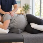 AI-generated illustration of care for back pain in late pregnancy, with a therapist gently massaging the back of a pregnant woman lying on her side with supportive pillows